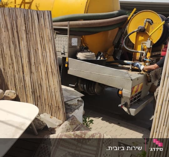 משאית ואקום צהובה עם צינורות וגלגלת